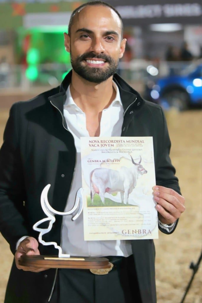 Eros Gazzinelli, da GenBra Agropecuária, segura troféu e certificado em homenagem à vaca Acácia FIV, nova recordista na categoria vaca jovem do Guzerá Leiteiro.
