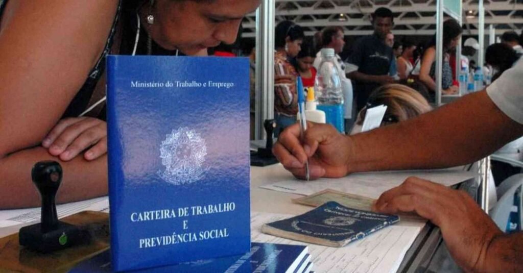 Profissional em posto de atendimento ao trabalho e carteira de trabalho em primeiro plano