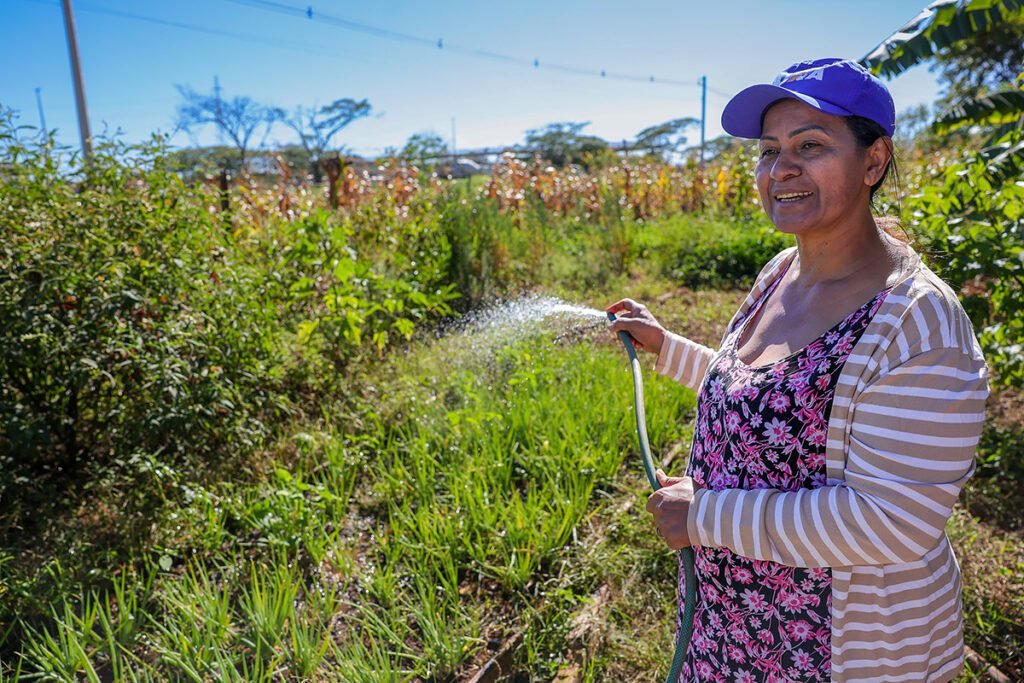 Nasaré Francisca da Silva rega horta na Floresta da Nasaré, em Ceilândia, projeto agroflorestal criado por ela a partir de um lixão